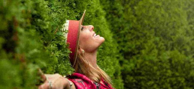 A joyful woman enjoying nature, embracing freedom in a lush green park., tags: und - pexel