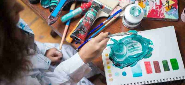 Top view of a child artist mixing vibrant paints with a brush on a canvas pad., tags: und gewohnheiten - pexel